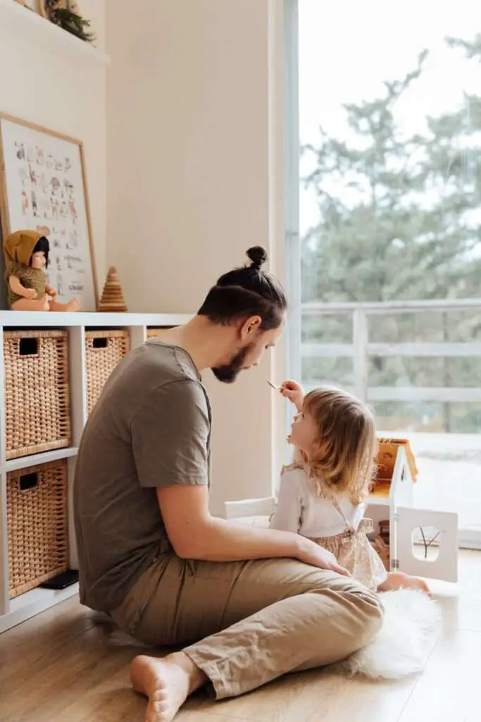 Co-parenting dad feeding his daughter, showcasing daily care routines.